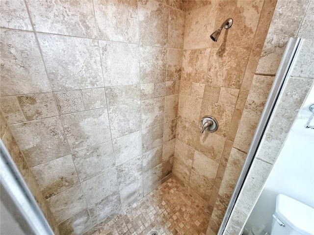 bathroom featuring toilet and tiled shower