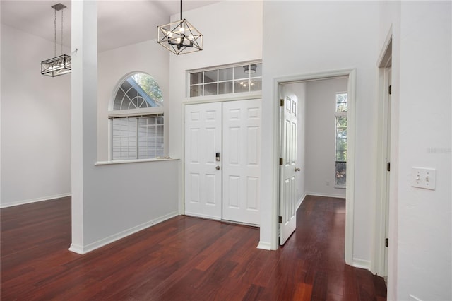 entrance foyer with dark wood-type flooring, a high ceiling, and a notable chandelier