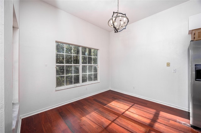 unfurnished dining area with hardwood / wood-style floors and an inviting chandelier