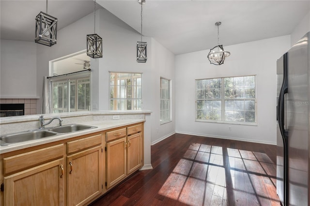 kitchen with hanging light fixtures, stainless steel refrigerator, dark hardwood / wood-style flooring, and a healthy amount of sunlight