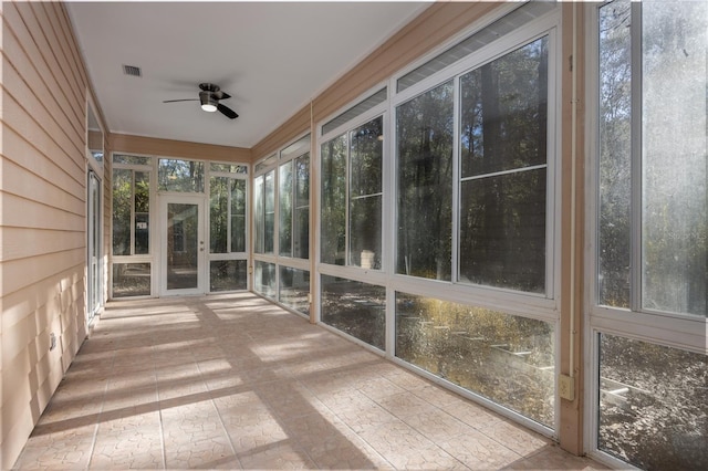 unfurnished sunroom with a wealth of natural light and ceiling fan