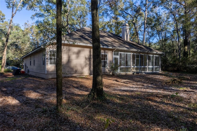 view of home's exterior with a sunroom