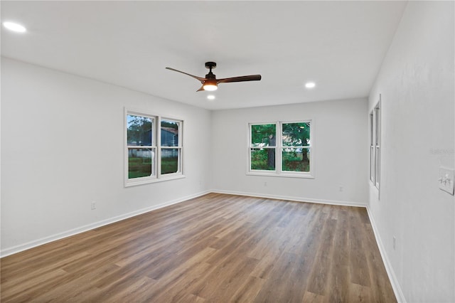 unfurnished room with wood-type flooring, plenty of natural light, and ceiling fan