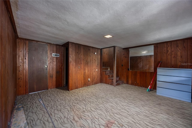 empty room featuring wooden walls and a textured ceiling