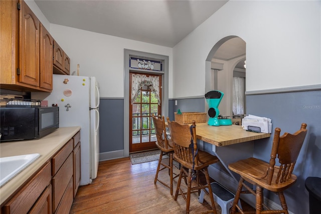 kitchen with lofted ceiling, white refrigerator, sink, light hardwood / wood-style flooring, and butcher block countertops