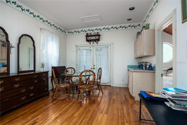 dining area featuring wood-type flooring, a wealth of natural light, and french doors