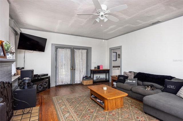 living room featuring a fireplace, ceiling fan, french doors, and dark wood-type flooring