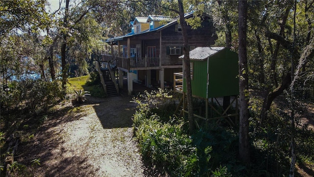 view of side of home featuring stairway and metal roof