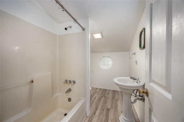 bathroom with bathing tub / shower combination and wood finished floors