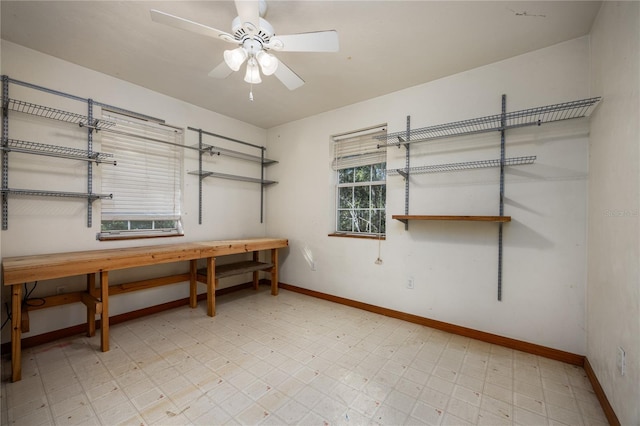 interior space with a ceiling fan, light floors, and baseboards