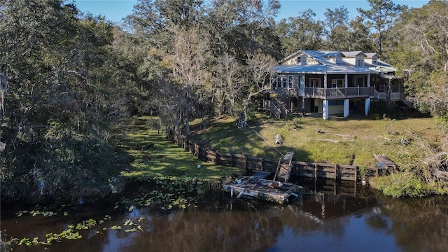 view of dock featuring stairs, a yard, fence, and a water view