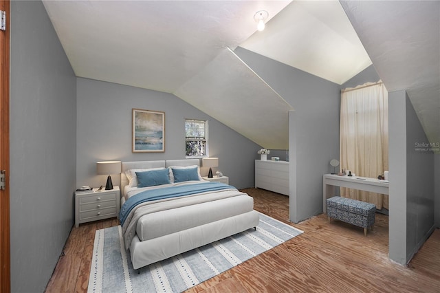 bedroom featuring lofted ceiling and wood finished floors