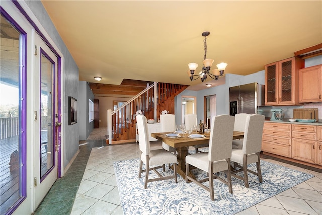 dining room with a notable chandelier, light tile patterned flooring, and stairs