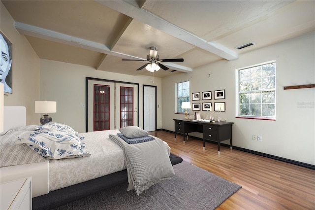 bedroom featuring visible vents, beamed ceiling, french doors, and wood finished floors