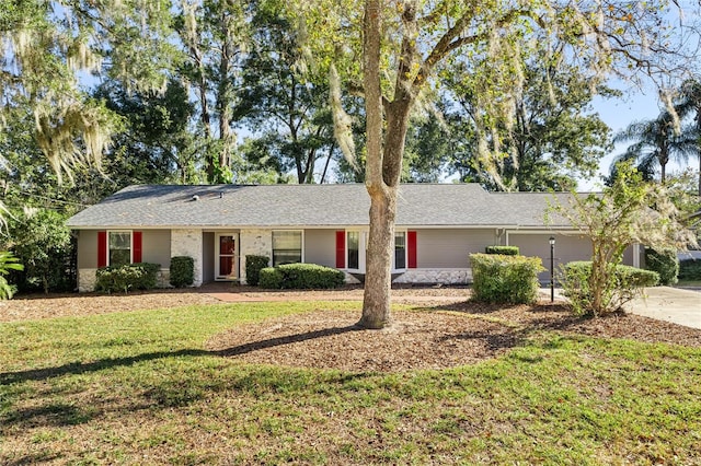 ranch-style home featuring a front lawn