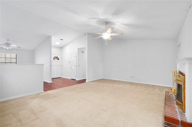 unfurnished living room featuring ceiling fan, carpet floors, and a brick fireplace