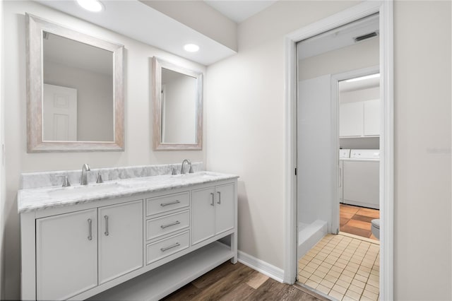 bathroom featuring vanity, wood-type flooring, and separate washer and dryer