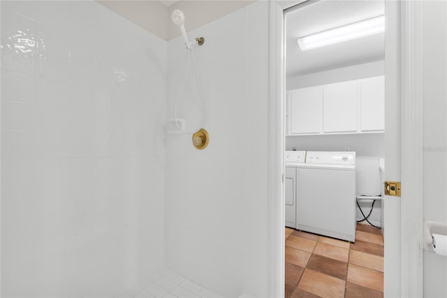 bathroom featuring washing machine and dryer and tiled shower