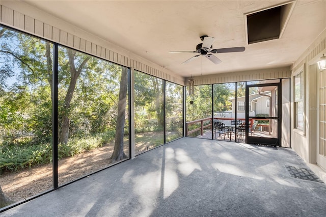 unfurnished sunroom featuring ceiling fan