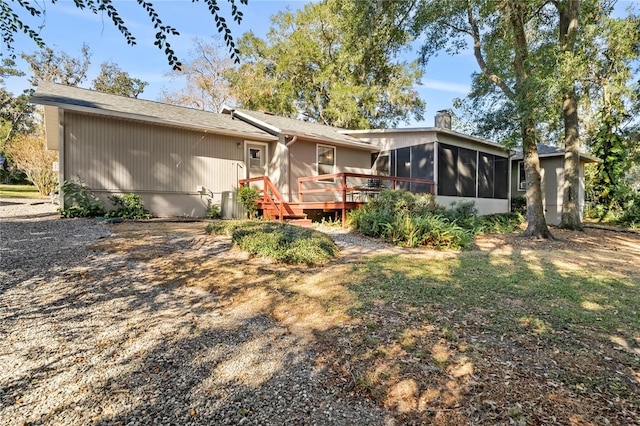 rear view of house featuring a sunroom and a wooden deck