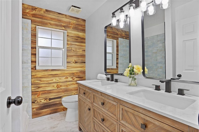 bathroom with vanity, toilet, and wooden walls