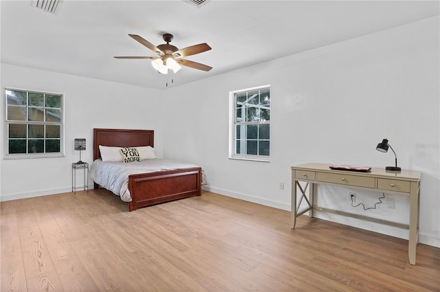 bedroom with multiple windows, ceiling fan, and light hardwood / wood-style flooring