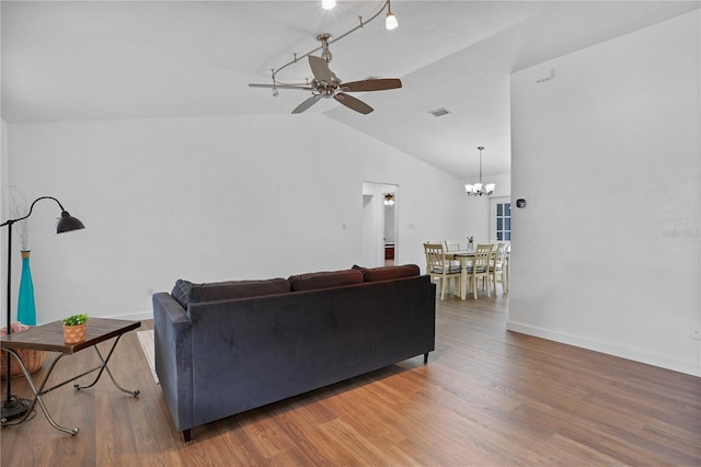 living room featuring ceiling fan with notable chandelier, dark hardwood / wood-style flooring, and lofted ceiling