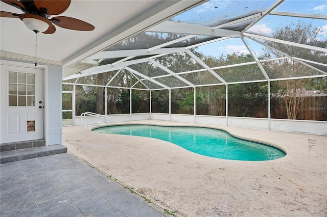 view of swimming pool featuring ceiling fan, a patio, and glass enclosure