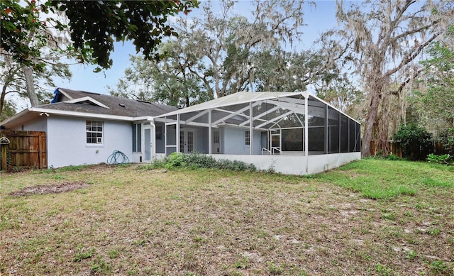 rear view of house featuring a yard and a lanai