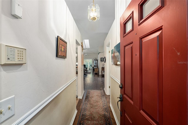 hall with a chandelier and dark hardwood / wood-style flooring