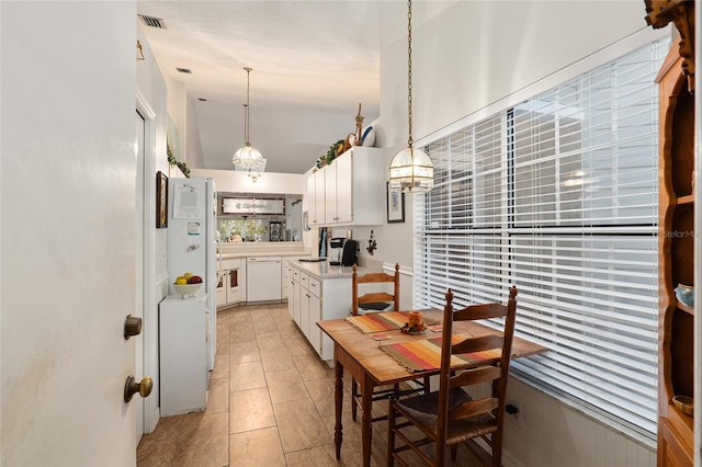 kitchen with light tile patterned floors, dishwasher, white cabinetry, hanging light fixtures, and lofted ceiling