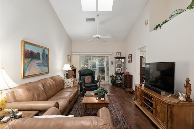 living room with a skylight, ceiling fan, dark hardwood / wood-style flooring, and high vaulted ceiling