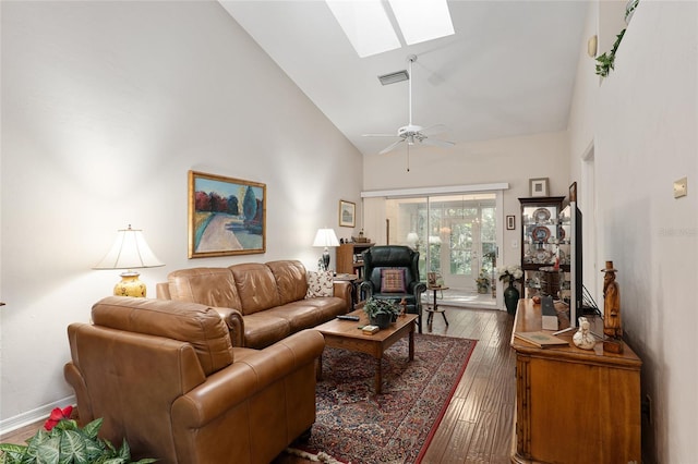 living room with a skylight, high vaulted ceiling, hardwood / wood-style flooring, and ceiling fan