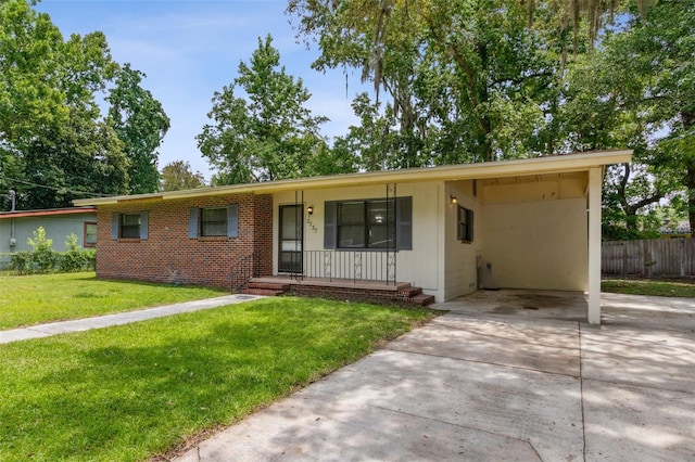 single story home with covered porch, a front yard, and a carport