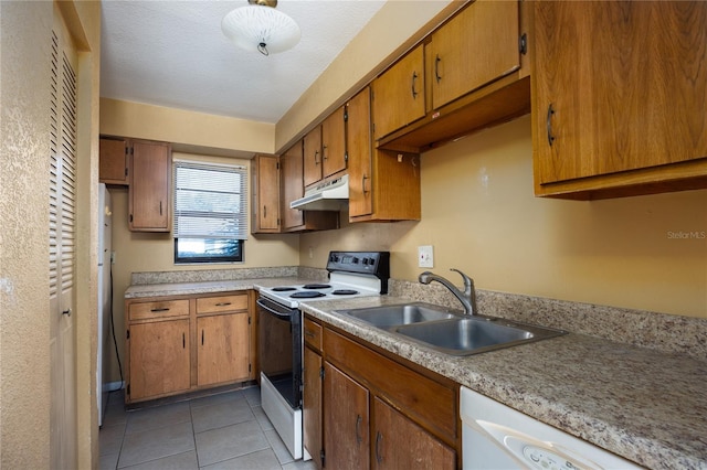 kitchen with a textured ceiling, light tile patterned flooring, white appliances, and sink