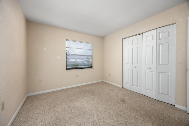 unfurnished bedroom with carpet floors and a closet