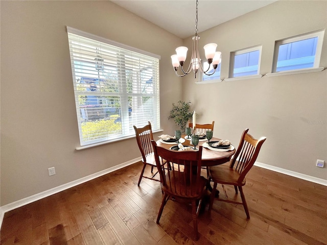 dining space featuring dark hardwood / wood-style flooring and an inviting chandelier