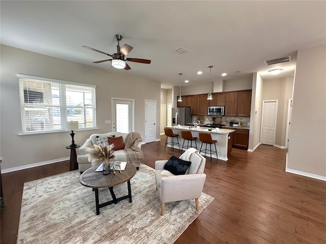 living room featuring ceiling fan and dark hardwood / wood-style flooring