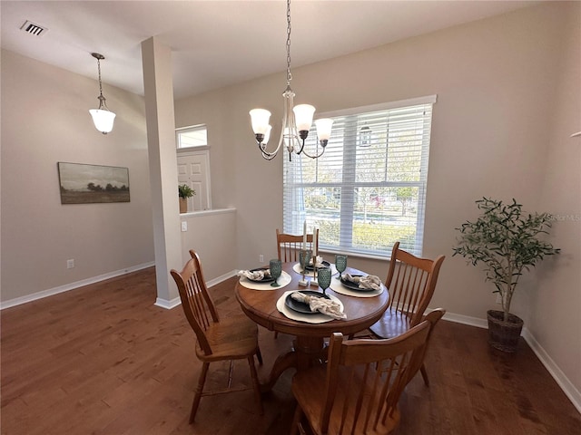 dining room with dark hardwood / wood-style floors and a notable chandelier