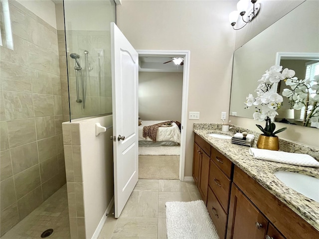 bathroom with tile patterned flooring, a tile shower, vanity, and ceiling fan