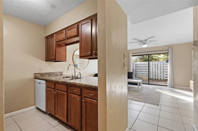 kitchen with dishwasher, sink, ceiling fan, light tile patterned floors, and a textured ceiling