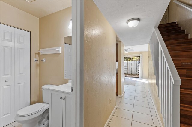 interior space featuring tile patterned floors, vanity, ceiling fan, and toilet