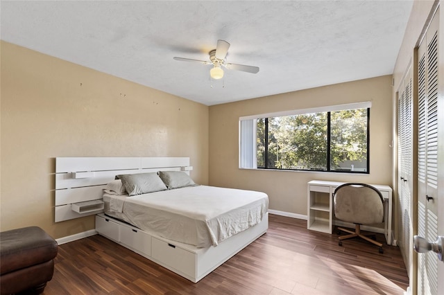 bedroom featuring a textured ceiling, ceiling fan, dark wood-type flooring, and a closet