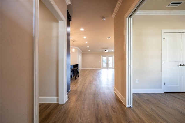 hallway featuring french doors, crown molding, and dark wood-type flooring