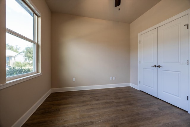 unfurnished bedroom with a closet, ceiling fan, and dark hardwood / wood-style flooring