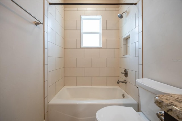 bathroom featuring tiled shower / bath and toilet