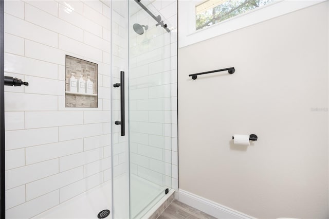 bathroom with hardwood / wood-style floors and a shower with shower door