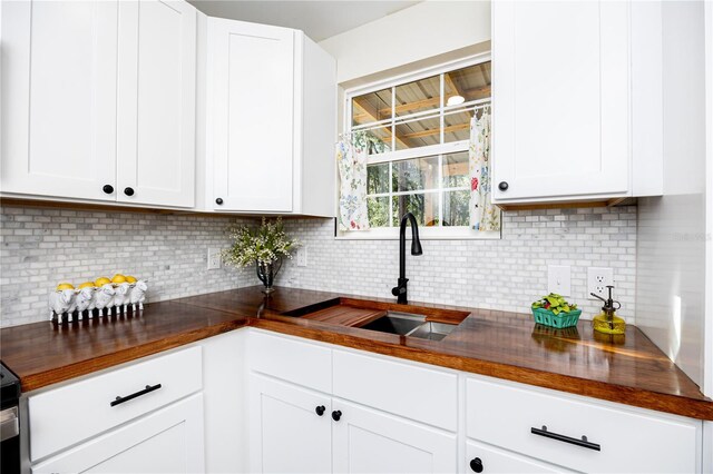 kitchen with sink, white cabinetry, and backsplash