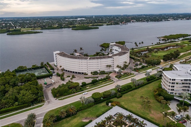 aerial view at dusk featuring a water view