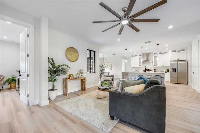 living room with ceiling fan and light wood-type flooring